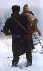 Poacher carrying a dead lynx